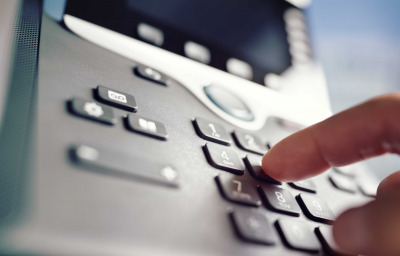 a person hand dialing a telephone