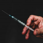 Doctor holding an injection with a needle