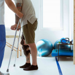 Injured patient learns to walk on crutches in medical office