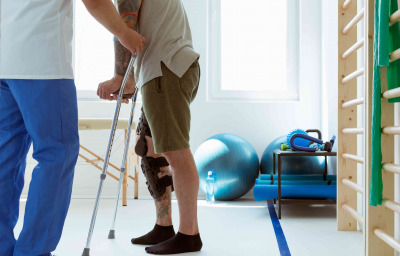 Injured patient learns to walk on crutches in medical office