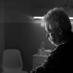 senior man sitting on the hospital bed alone at night