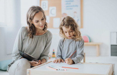 Little school boy during study session with teacher