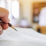 Students hands taking exams, writing examination room with holding pencil