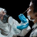 Woman doctor wearing hazmat suits taking a nasal swab to test for possible coronavirus infection