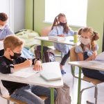 Kids protecting themselves with face masks in class
