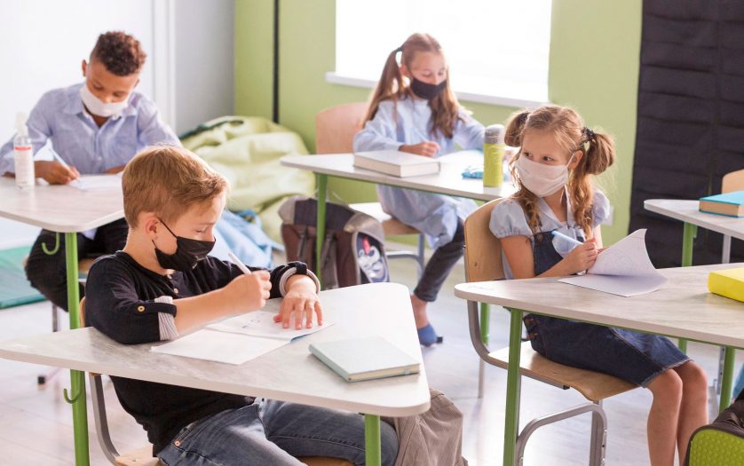Kids protecting themselves with face masks in class