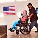 Young man pushing his father in wheelchair