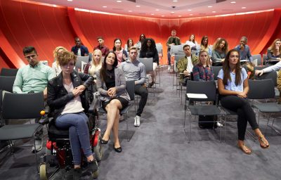 Students sit facing camera in a modern university classroom