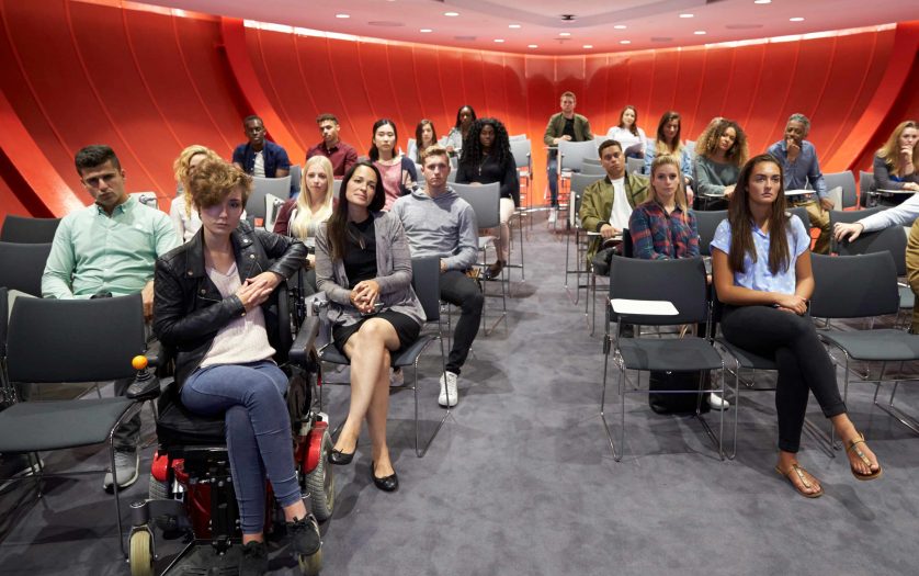 Students sit facing camera in a modern university classroom