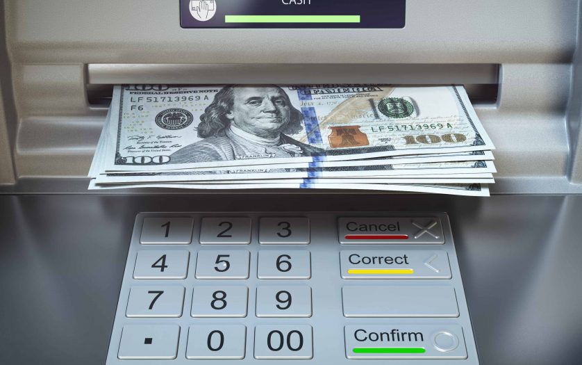 ATM machine and money. Withdrawing dollar banknotes