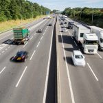 An aerial view of a busy UK motorway or highway with speeding cars and traffic and copy space