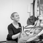 A disabled child in a wheelchair being cared for by a care worker