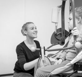 A disabled child in a wheelchair being cared for by a care worker