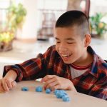 child in wheelchair molding clay