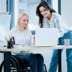 Front view of woman in wheelchair working at desk