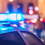 Blue flasher on the police car at night.