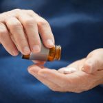 Closeup senior man taking pills