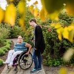 woman in wheelchair with assistant in garden