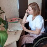 A female freelancer in a wheelchair, works remotely from home