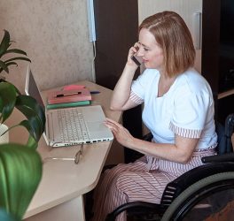 A female freelancer in a wheelchair, works remotely from home