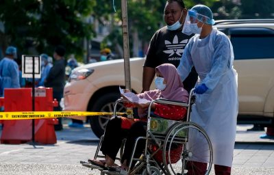 Medical personnel helps a woman in wheelchair to do the COVID-19 test to taking nasal and mouth swab at Kampung Baru.