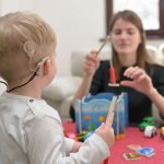 A Boy With A Hearing Aids And Cochlear Implants Playing