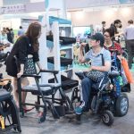 a wheelchair user speaking to the exhibitor
