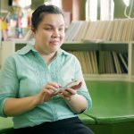 blind woman using smart phone with voice accessibility for persons with disabilities