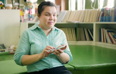 blind woman using smart phone with voice accessibility for persons with disabilities