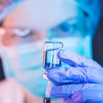 Doctor with syringe and vaccine for COVID-19