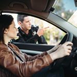 Male cop in uniform shows the way to female driver