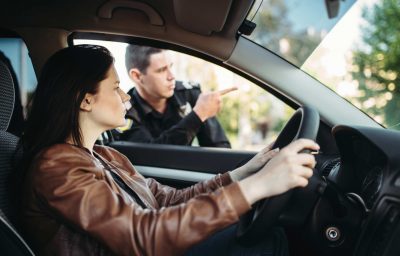 Male cop in uniform shows the way to female driver