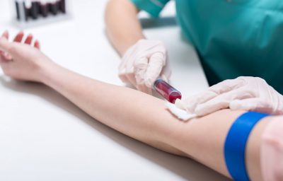 cropped shot of nurse taking blood sample of patient with syringe