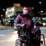 man in wheelchair wearing medical face mask for coronavirus protection.