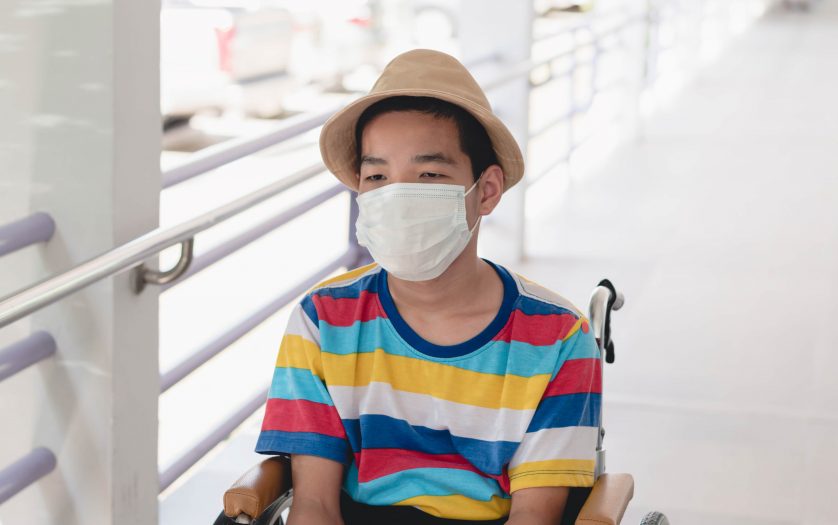 Boy in wheelchair wearing a protection mask against Covid 19