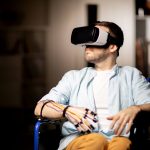 man in wheelchair traveling in virtual reality while spending time at home