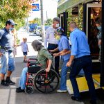 A passenger with disabilities gets off the bus