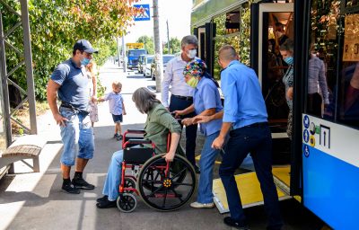 A passenger with disabilities gets off the bus