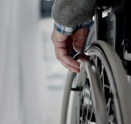 Close-up view of senior man hand on wheel of wheelchair