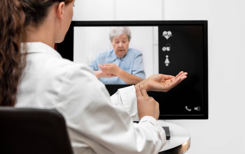 Doctor and senior women taking the pulse together, telemedicine and videotelephony for medical health care