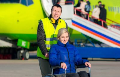 Airlines staff pushing the woman in wheelchair in the airport