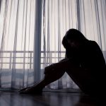 woman sitting alone near window