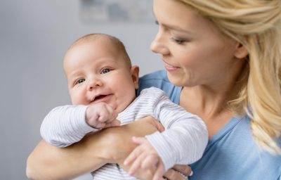 portrait of young mother holding infant in hands