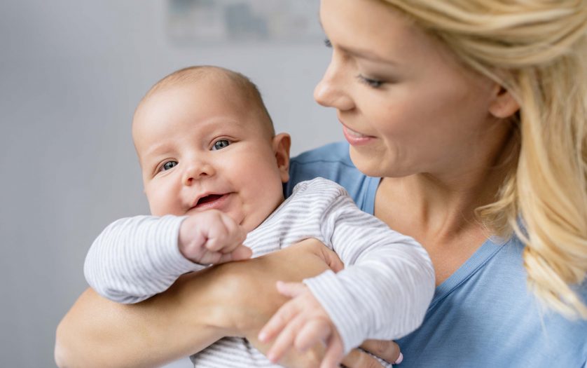 portrait of young mother holding infant in hands