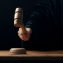 Hand banging gavel on dark background, the judge makes a verdict