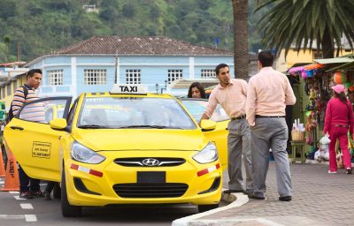 Unidentified taxi drivers talking at taxi stand on 12 de Noviembre Street outside the cathedral