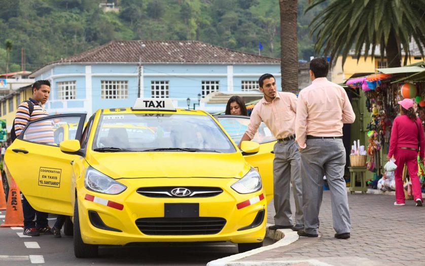 Unidentified taxi drivers talking at taxi stand on 12 de Noviembre Street outside the cathedral