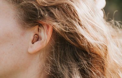 small intra channel hearing aid in the ear of a woman