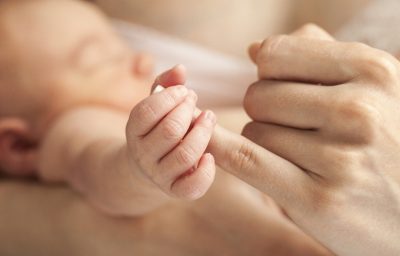 Newborn baby holding mother's hand