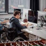 man in wheelchair working in the office